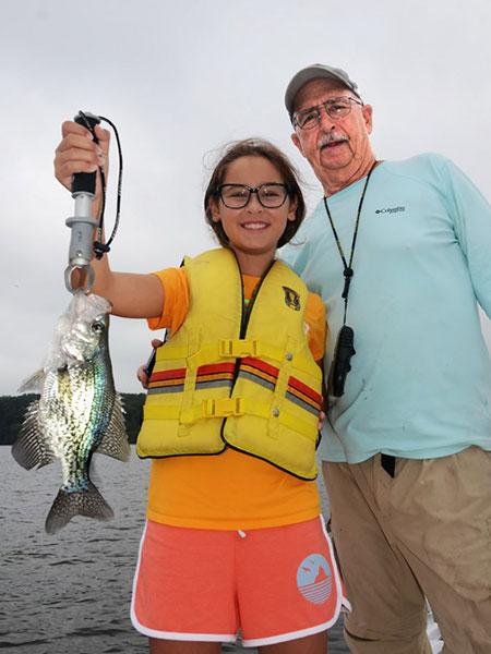 Grace and granddad Dave pose with crappie.